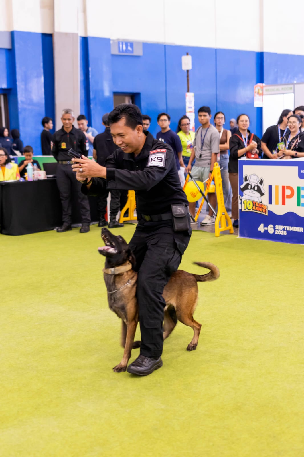 Handler berinteraksi dengan anjing K9 di pameran IIPE.